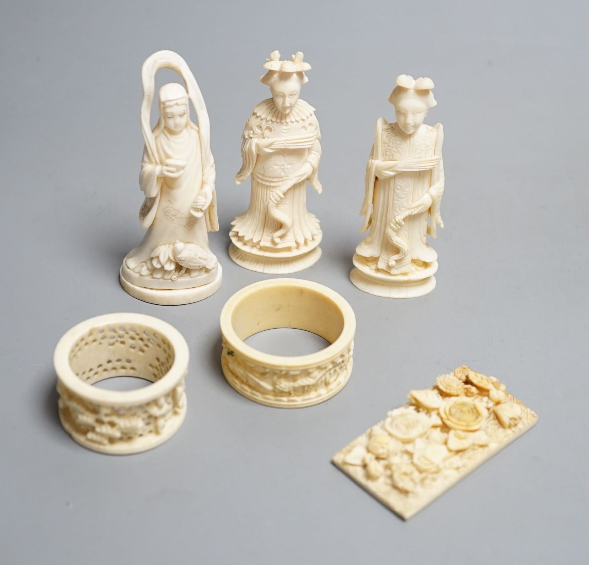 A Chinese ivory figure of Guanyin, a pair of ivory chess pieces, two Cantonese napkin rings and a Cantonese ivory plaque with flowers, 19th/early 20th century , tallest chess piece 8.5 cms high.